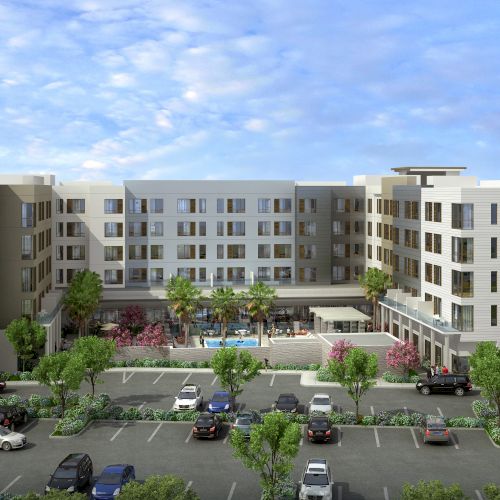 The image shows a large hotel complex with multiple floors, a central courtyard with a pool, and a parking lot in the foreground.